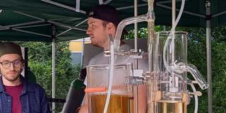 Der Doktorand Jan Graw vor der Modellkläranlage am Stand des Biozentrums
