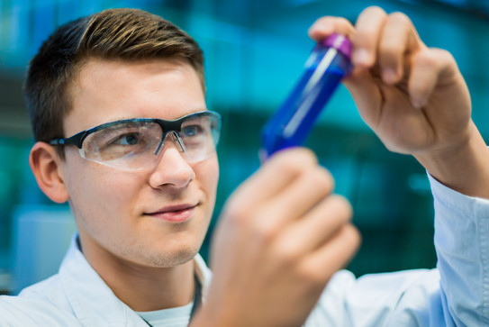 Forschende mit Probengefäß Eine forschende Person hält ein Probengefäß in der Hand.